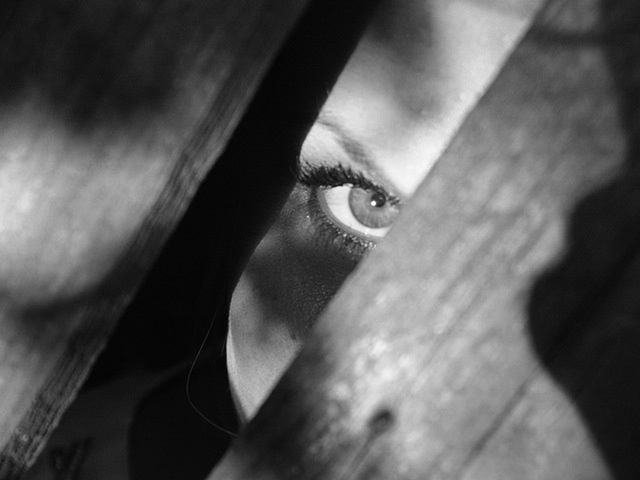 woman peeking from behind a door