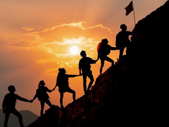  Licensed  Save to Library  Preview Crop  Find Similar  Expand Image   FILE #:  300949929 Silhouette of people helping each other hike up a mountain at sunset background. in piece about customer journey orchestration.