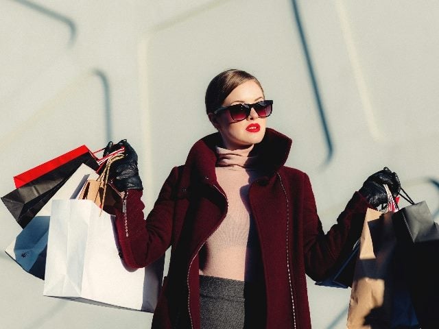 Woman holding multiple shopping bags.