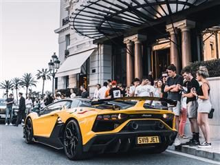 lamborghini parked in front of a hotel with a crowd surrounding it