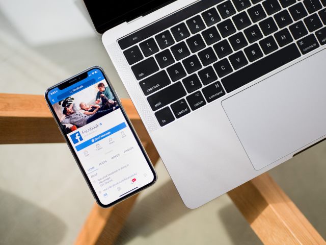 phone and laptop with a facebook logo showing