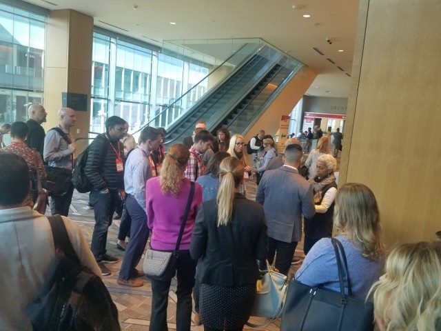 Attendees of the DX Summit wait outside a breakout session.