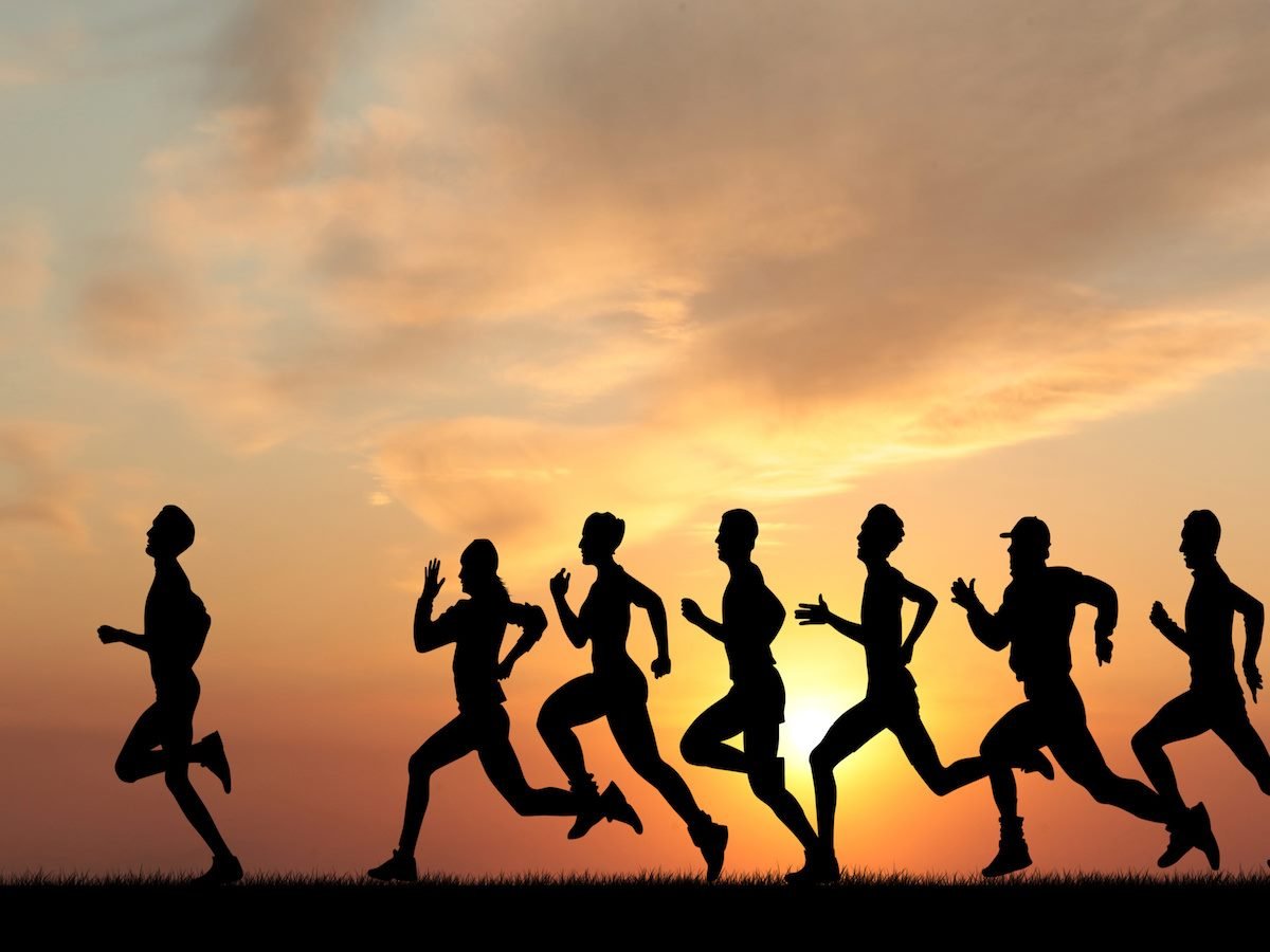 A group of people running, with one person in the lead