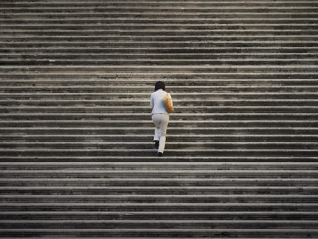 woman walking up a long flight of stairs