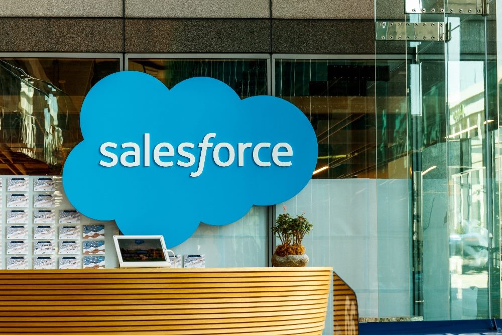 A closeup to the entryway of Salesforce building with a wooden desk and the logo visible in piece about the demise of the Salesforce-Informatica deal.