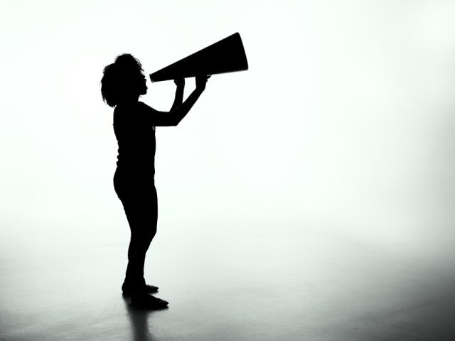 silhouette of a woman holding a megaphone in front of a white background