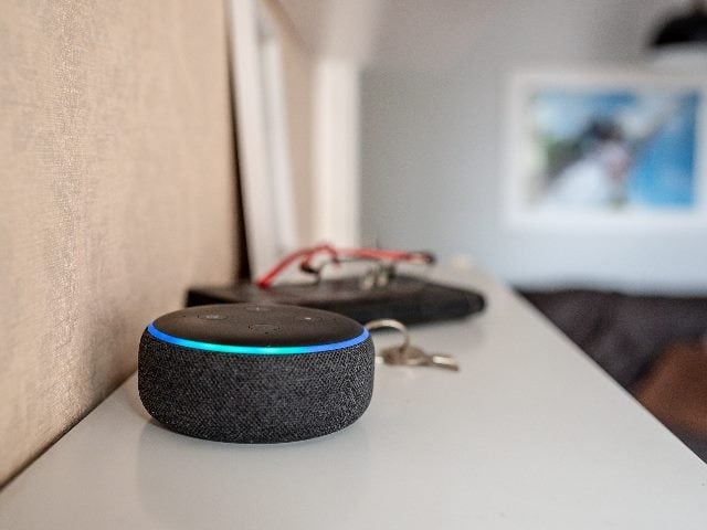 Amazon Echo Dot smart speaker with integrated Alexa voice assistant, in a home next to a set of keys. 
