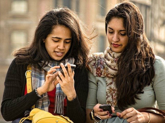 Two women looking at smartphones.