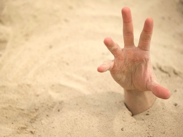 hand reaching out of quicksand