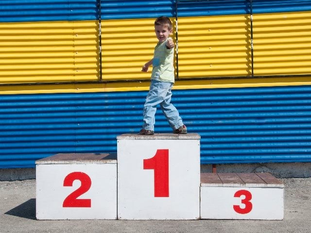 Boy on the podium standing on the No. 1 block, with No. 2 and No. 3 empty, symbolizing email marketing trends marketers find successful lately.