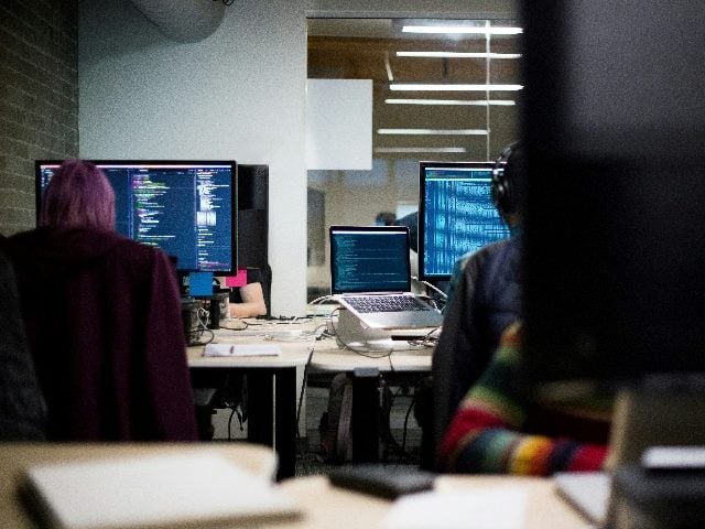Contact center in operation from behind two workers.
