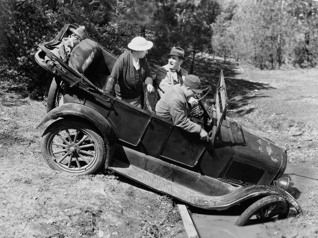 A black and white photo shows three people sit stranded in an antique car after missing a turn and ending up in a muddy ditch in piece about the biggest customer experience mistakes of 2023.