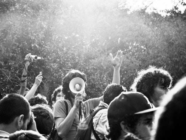 Person with a megaphone among a crowd.
