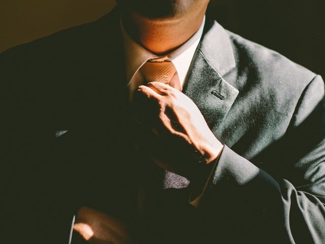 man in a suit adjusting his tie
