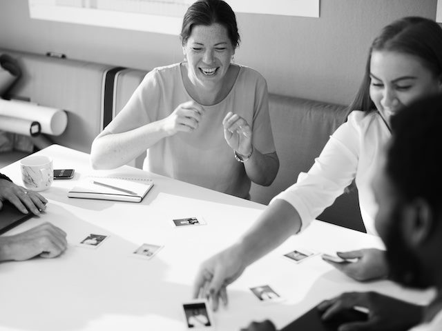 people sitting around a table looking at photographs