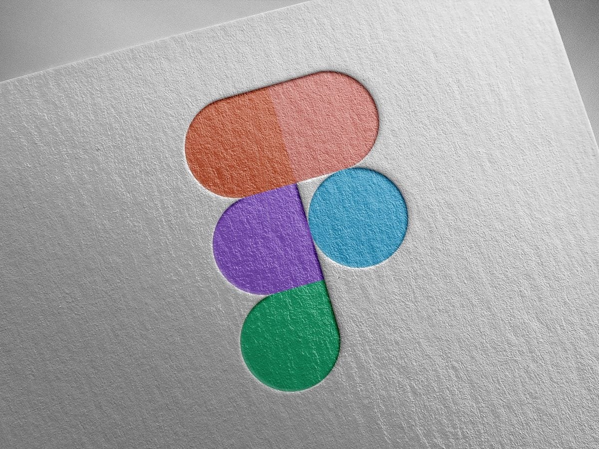 Figma logo composed of overlapping red, pink, purple, blue and green geometric shapes printed on textured white paper background.