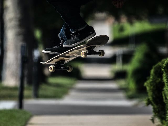 skateboarder  doing an ollie, feet and board only parts visible, up in the air
