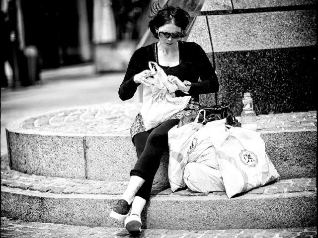 woman sitting outside with shopping bags