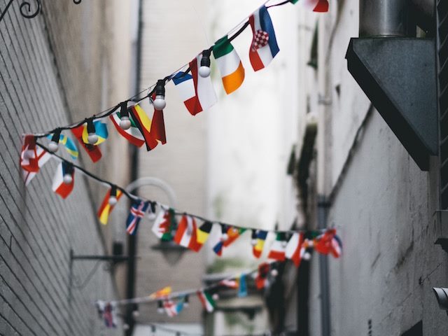 international flags hanging in an alley