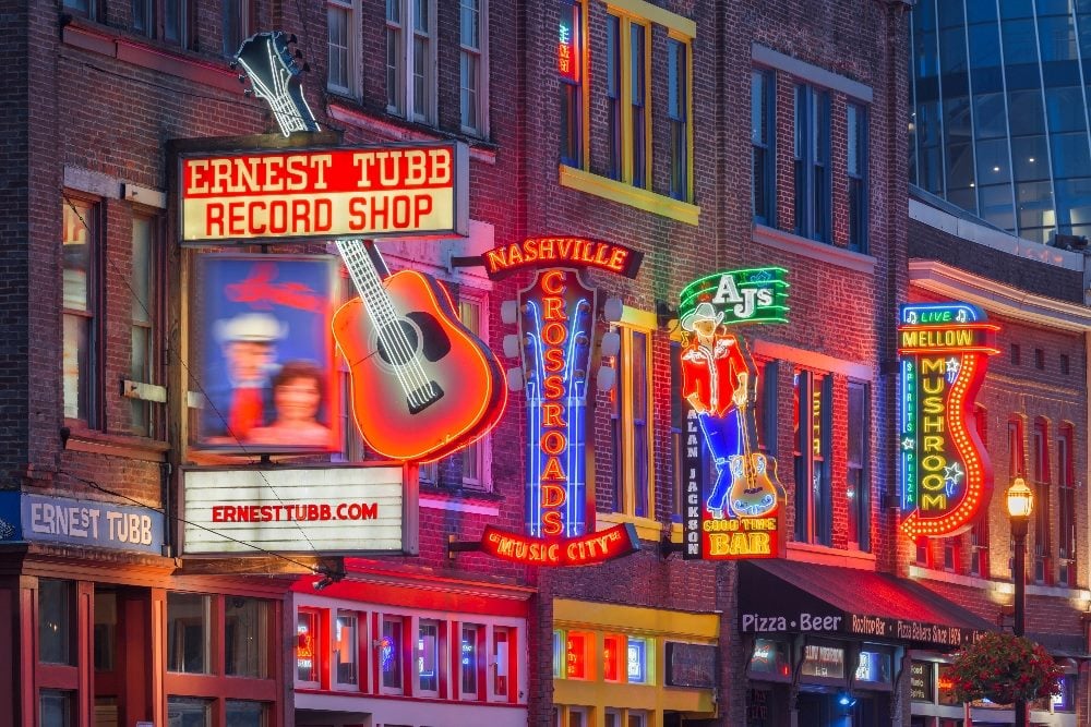 Neon signs for stores and bars on Lower Broadway in Nashville, Tennessee, in piece about Kentico Connection conference.