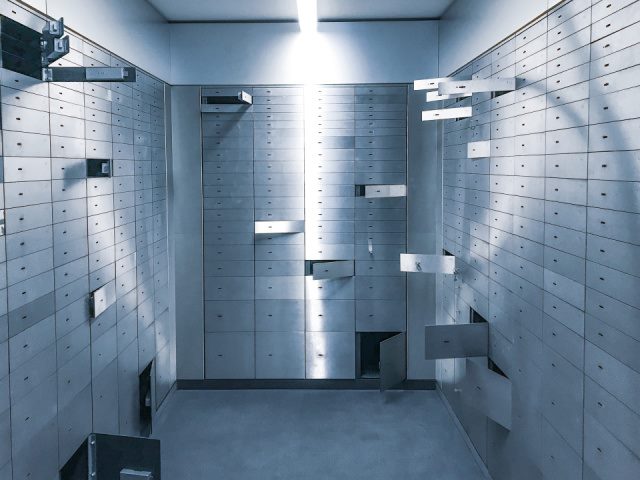 bank vault with multiple safe deposit boxes unlocked and open