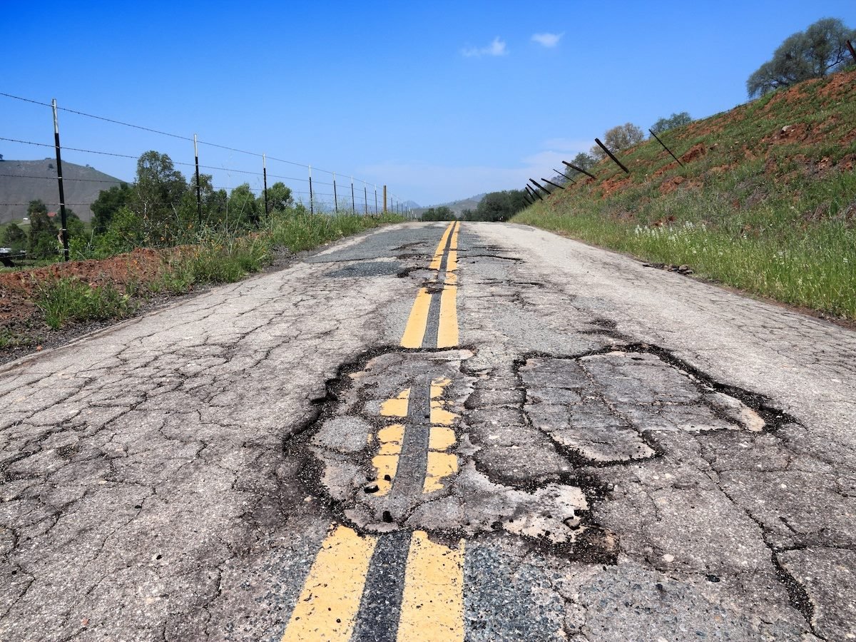 A road with cracks and potholes
