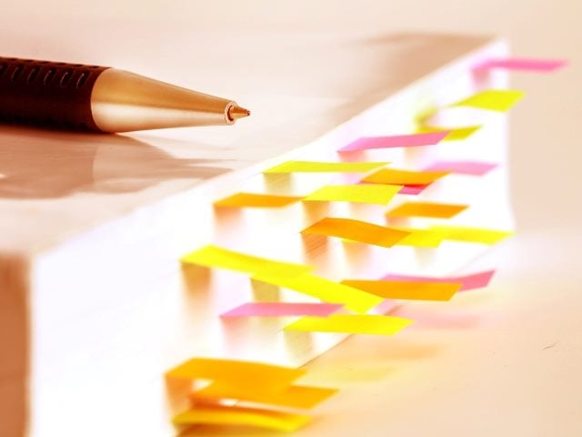 Book with bookmarks and a pen