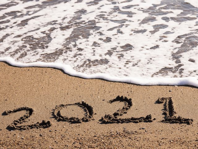 2021, written in the sand and about to be wiped out by the ocean
