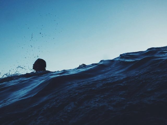 person's head above rough seas.