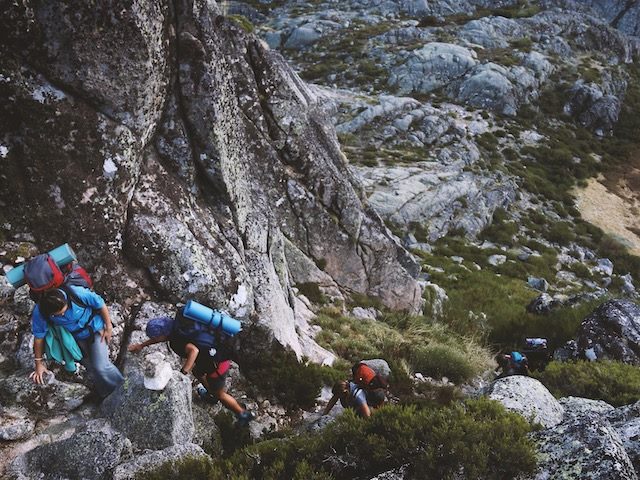 three mountain climbers going uphill in rocky terrain in Portugal