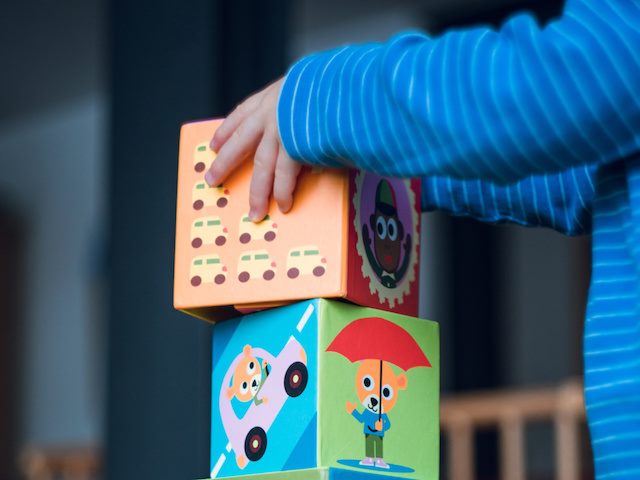 child stacking up building blocks