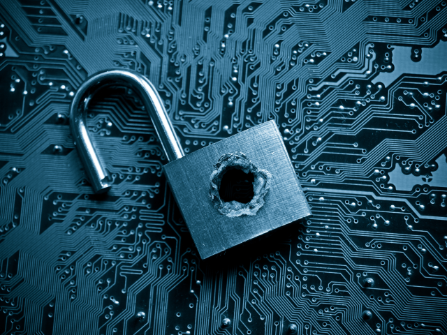 A broken security lock with a bullet hole on top of computer circuit board - Vulnerable data concept