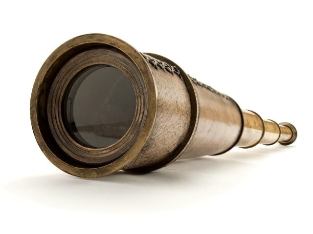 Closeup of a vintage brass spyglass on a white background symbolizing how causal AI can lead to deeper marketing insights. 