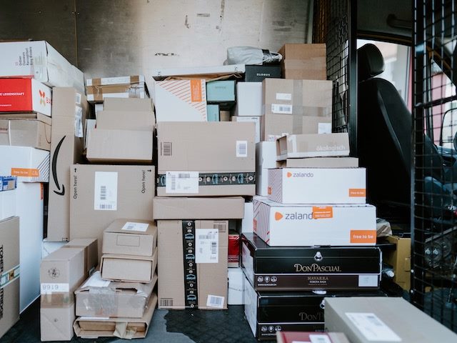 large pile of packages in the back of a delivery truck
