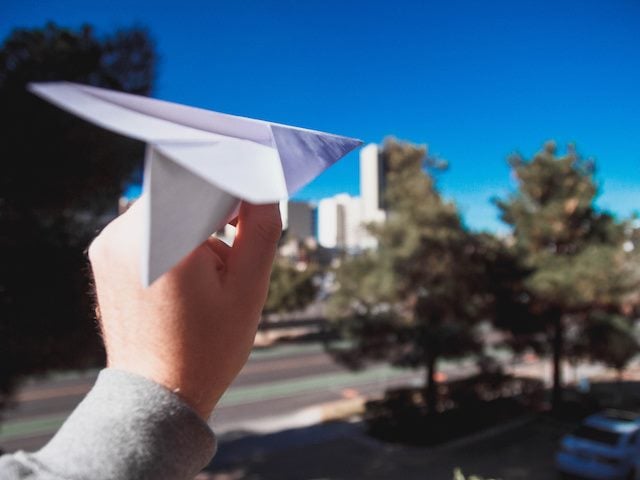 someone about to launch a paper airplane
