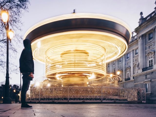 man viewing  a quickly spinning carousel