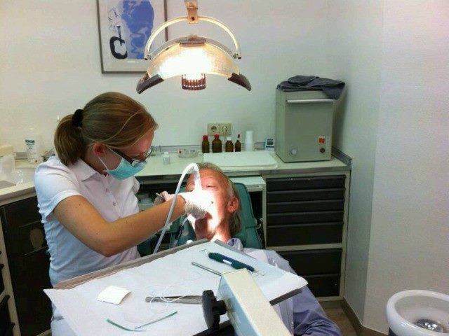 A dentist works on a patient's teeth.