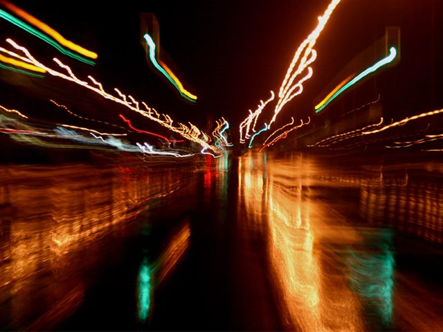 Image of streetlights blurred with reflections on the ground after the rain. 