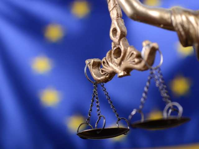 Scales of Justice in front of the European Union flag