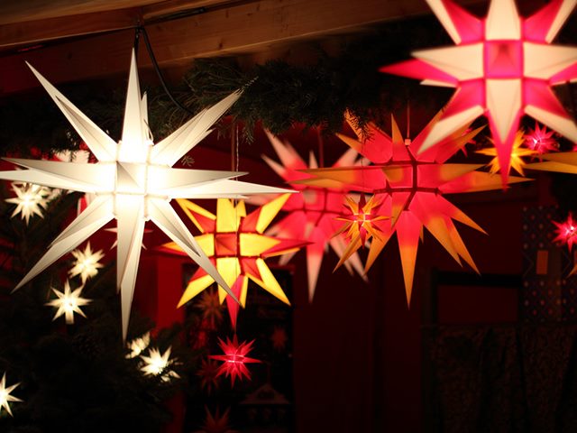 Paper star lanters illuminated in the dark.