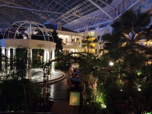 The scene indoors at the Gaylord Opryland Resort & Convention Center, including palm trees, other plants and a white gazeebo.