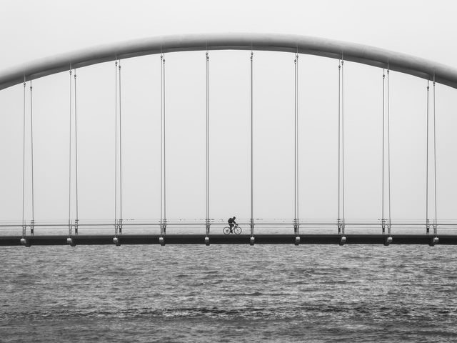 man riding a bike on a bridge