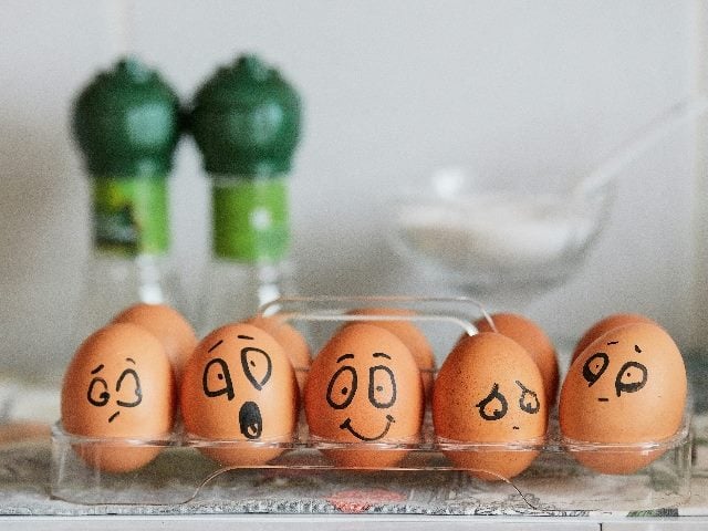 A row of eggs with human emotions painted on them.