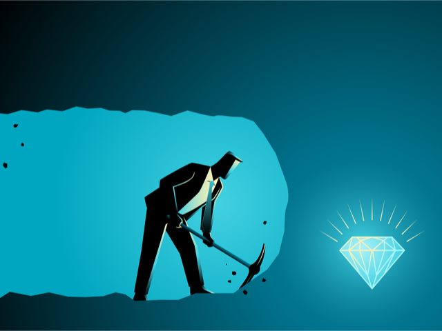 A businessman using a pick ax to mine for a gem - process mining concept