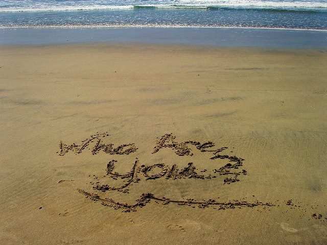 "who are you," written in sand