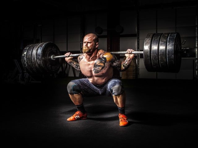 strong man lifting barbells