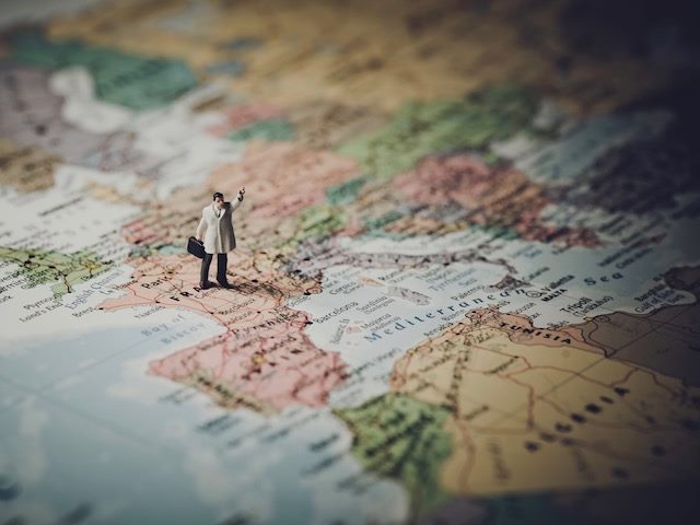 miniature figurine of business man on a world map