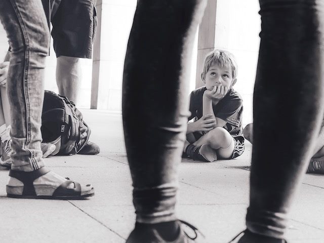 child sitting on floor listening with great concentration