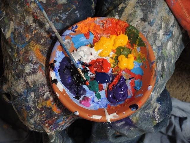 paint on a palette, with some colors being blended