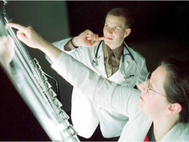 doctor examining an x-ray with a student